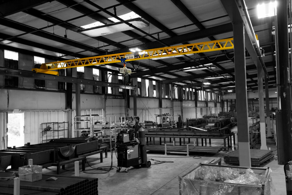 man operating 3 ton pwi ultralite crane in trailer manufacturing setting 2