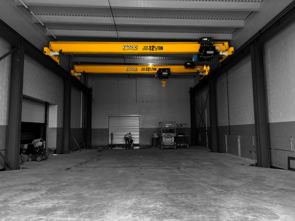 multiple 12.5 ton pwi freestanding top running motorized bridge cranes shaw box hoists in manufacturing setting 2