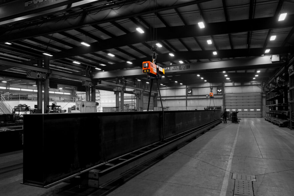 pwi torquewp rotation device lifting and rotating steel beam in manufacturing setting